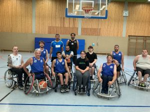 Elf Spieler der Rollstuhlbasketballmannschaft Rolling Chocolate und Torwartlegende Henning Fritz